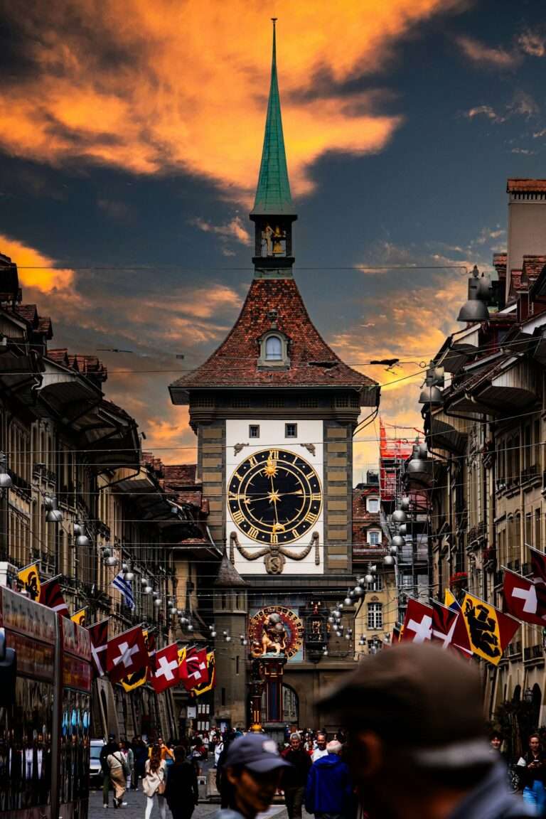 The Zytglogge clock tower over a flag-lined lane in Bern's old town